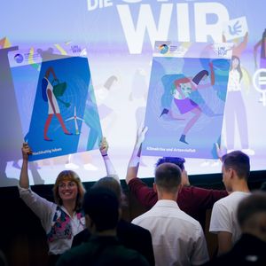 Bühne mit angeleuchteten Plakaten auf der Jugendkonferenz 2023