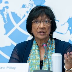 Navanethem Pillay Eine Frau mit kurzen schwarzen Haaren und einer Brille hält vor einem UN-Logo eine Rede