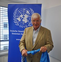 Detlef Dzembritzki, Vorsitzender der DGVN mit einem Knoten in der UN-Flagge