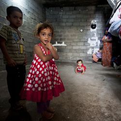 UNHCR helps displaced in Erbil, Iraq, 2011 ©UN Photo/Bikem Ekberzade Zwei Kinder und ein Säugling befinden sich in einem geziegelten Unterkunft und schauen in die Kamera