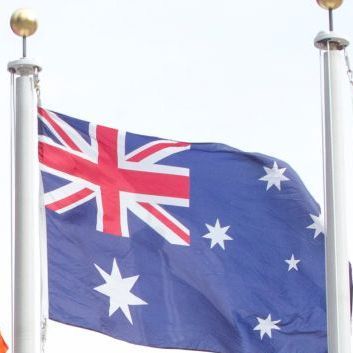 Die australische Flagge mit blauem Untergrund, weißen Sternen und einer kleinen britischen Flagge weht an einem Fahnenmast.