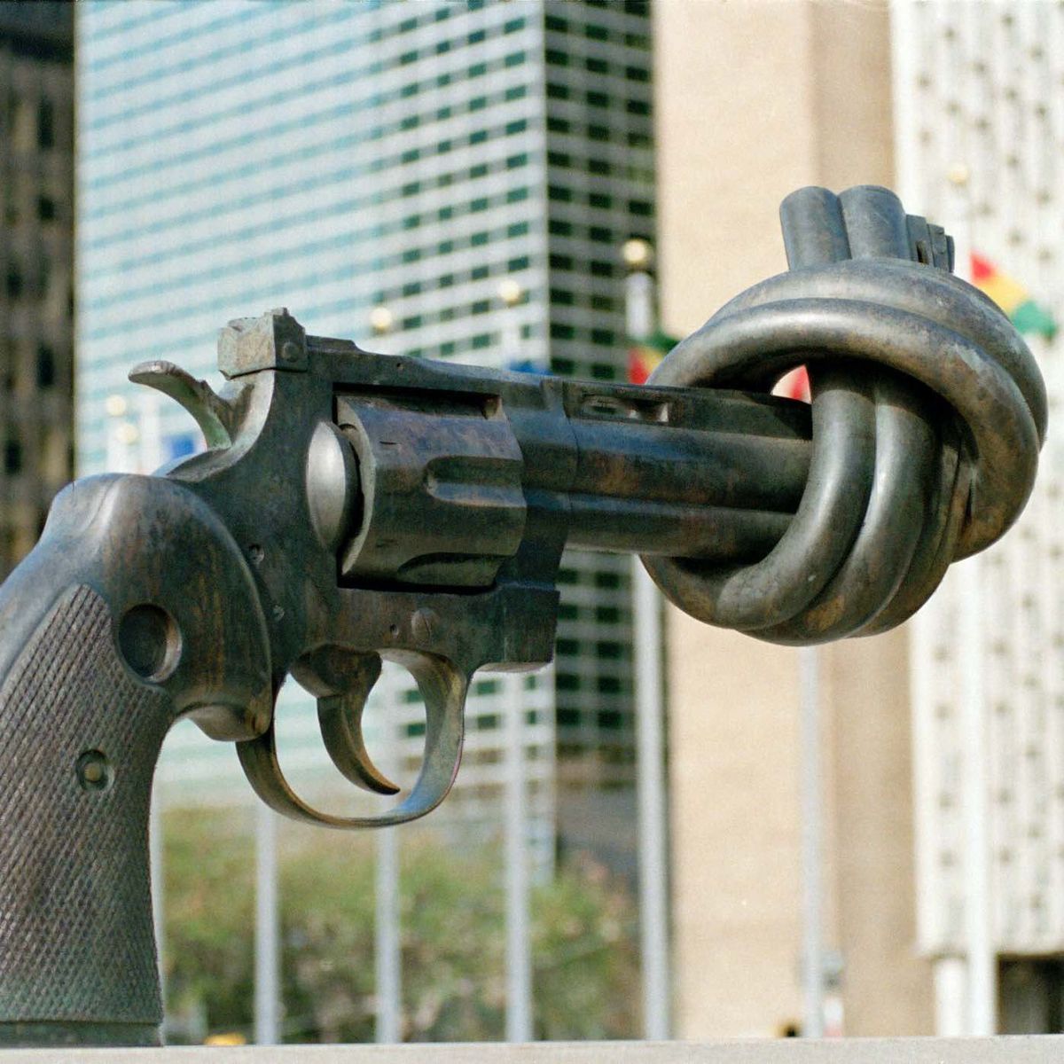 Die Bronzenachbildung zeigt einen 45-Kaliber-Revolver, dessen Lauf verknotet ist. Im Hintergrund sieht man die Gebäude des UN-Hauptquartiers in New York und einige Flaggen verschiedener Länder.