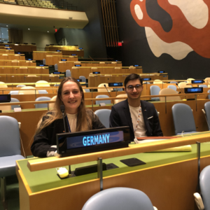 Eine Frau und ein Mann sitzen in einem Konferenzraum.