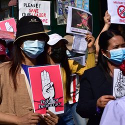Demonstrierende Menschen in Myanmar mit Plakaten.