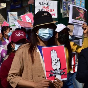 Demonstrierende Menschen in Myanmar mit Plakaten.