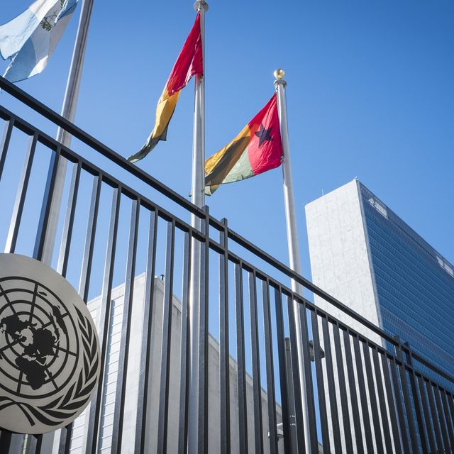 Das Hauptquartier der Vereinten Nationen (UN) und die Flaggen der UN-Mitgliedstaaten Guatemala, Guinea und Guinea-Bissau, aufgenommen von vor dem Eingangstor an der First Avenue in New York City. 