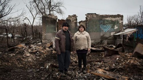Ein Paar vor den Trümmern ihres Hauses in der Ostukraine.