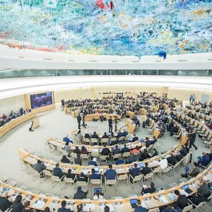 Großer Sitzungssaal mit vielen halbrunden Tischreihen.