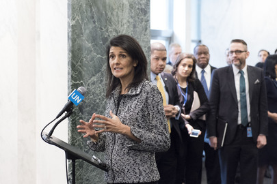 Die US-amerikanische UN-Botschafterin Nikki Haley spricht in ein Mikrofon. Im Hintergrund steht eine Gruppe aus Pressevertretern.