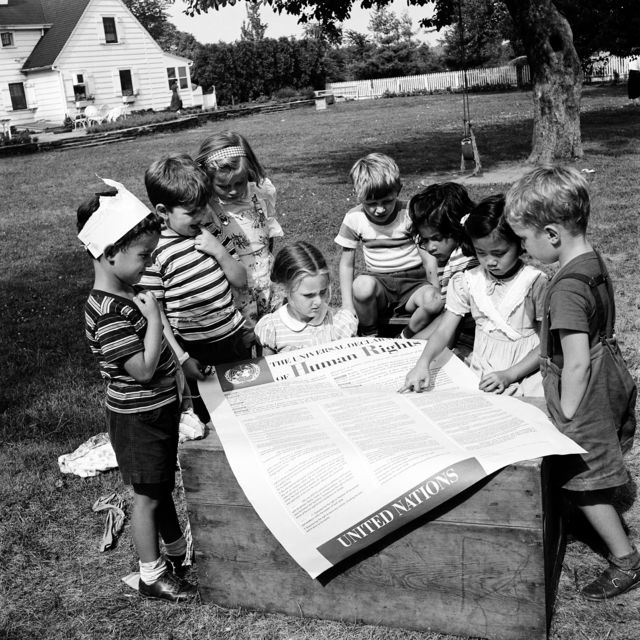 Dezember 1950: Kinder von Mitarbeiterinnen und Mitarbeitern der Vereinten Nationen werfen einen Blick auf die Allgemeine Erklärung der Menschenrechte. © UN Photo