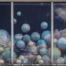 Wilde Ansammlung von Globen hinter einem dreigeteilten Fenster