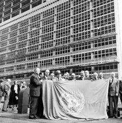 UN-Generalsekretär Trygve Lie und Mitglieder des Beratenden Ausschusses für den Sitz der Vereinten Nationen mit der UN-Flagge