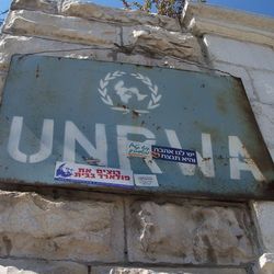 rostiges UNRWA-Eingangsschild mit israelischen Stickern